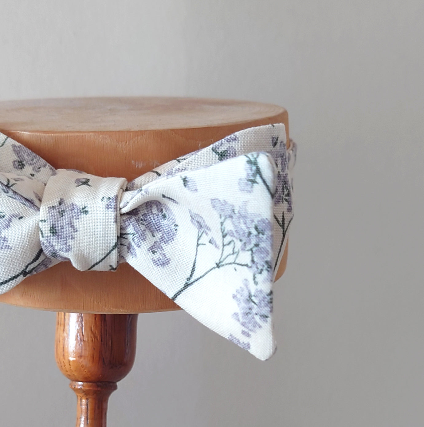 ivory and grey floral wedding bow tie on a display