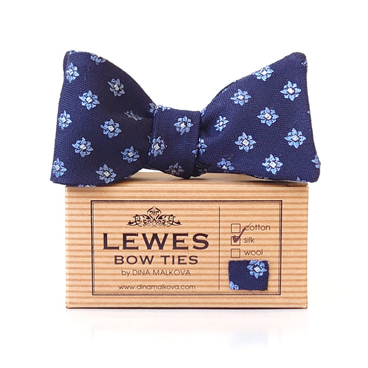 A navy blue bow tie with light blue and white floral weave