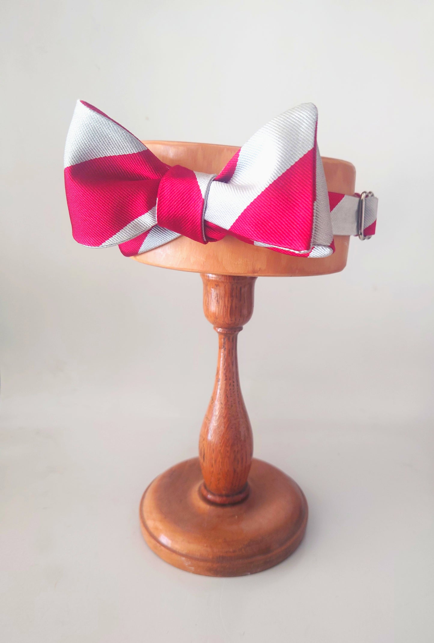 Red and silver bow tie on a wooden stand ready for Christmas celebrations