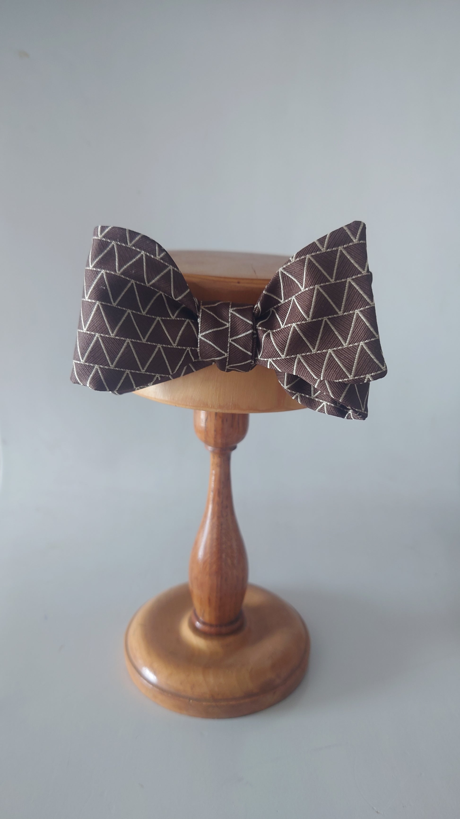 Brown silk geometric pattern bow tie on stand