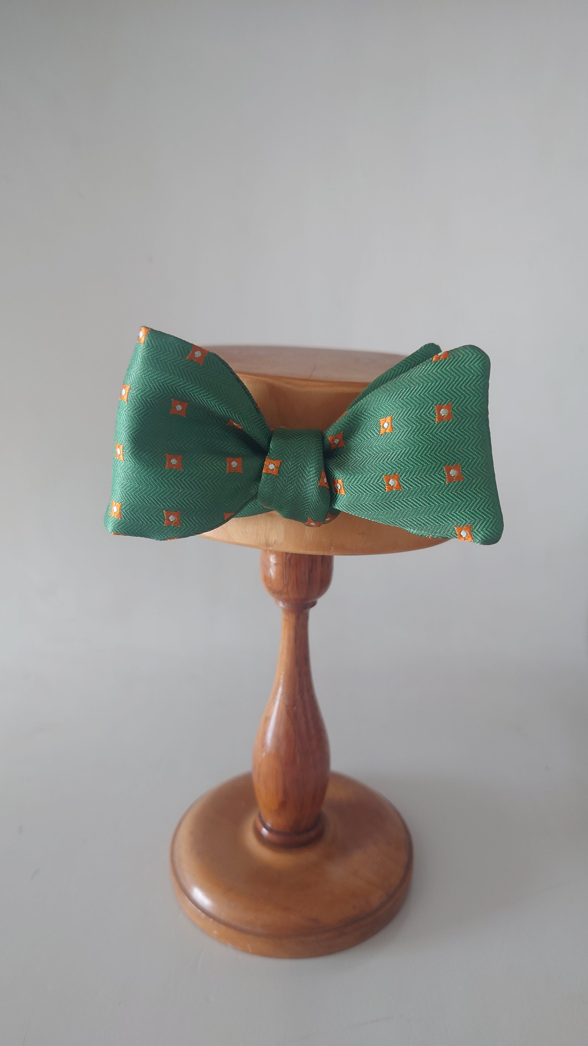 Green silk bow tie on stand