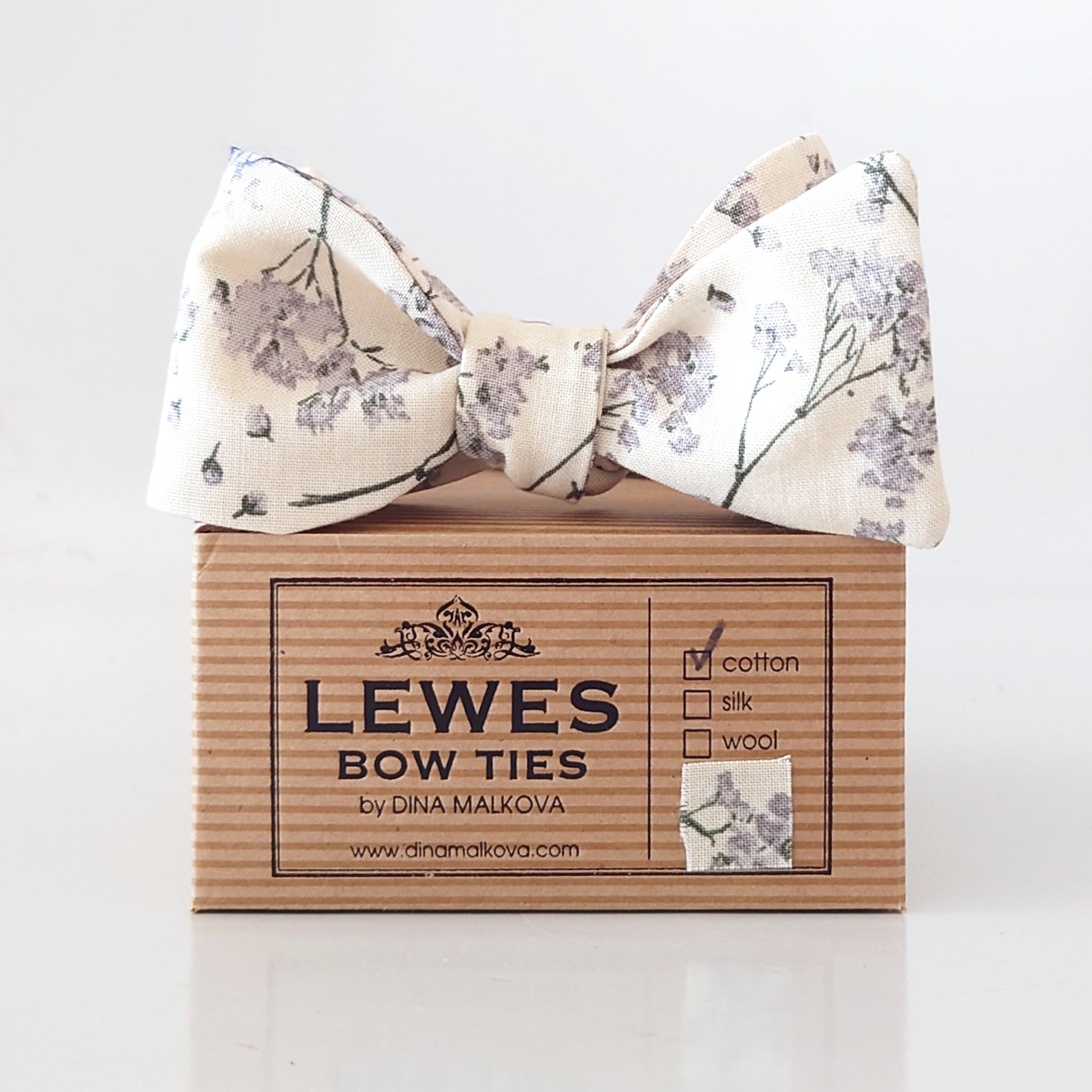 Floral bow tie on a box with 'Lewes Bow Ties' branding.